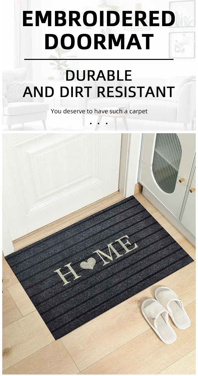 Embroidered doormat with 'HOME' and heart design on a wooden floor.