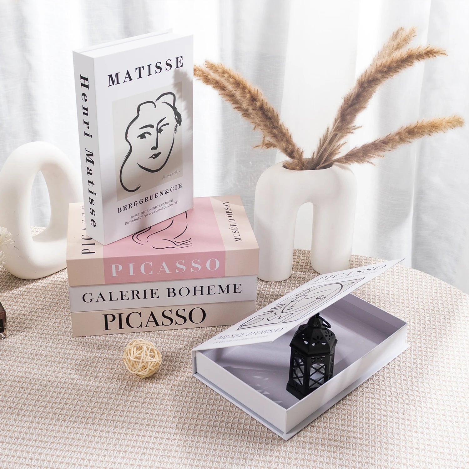 Stack of books with art-themed covers on a textured surface with decorative elements.