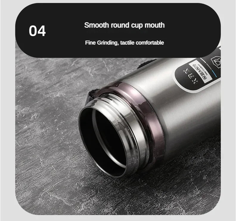 Silver thermos bottle with a smooth round cup mouth on a gray surface