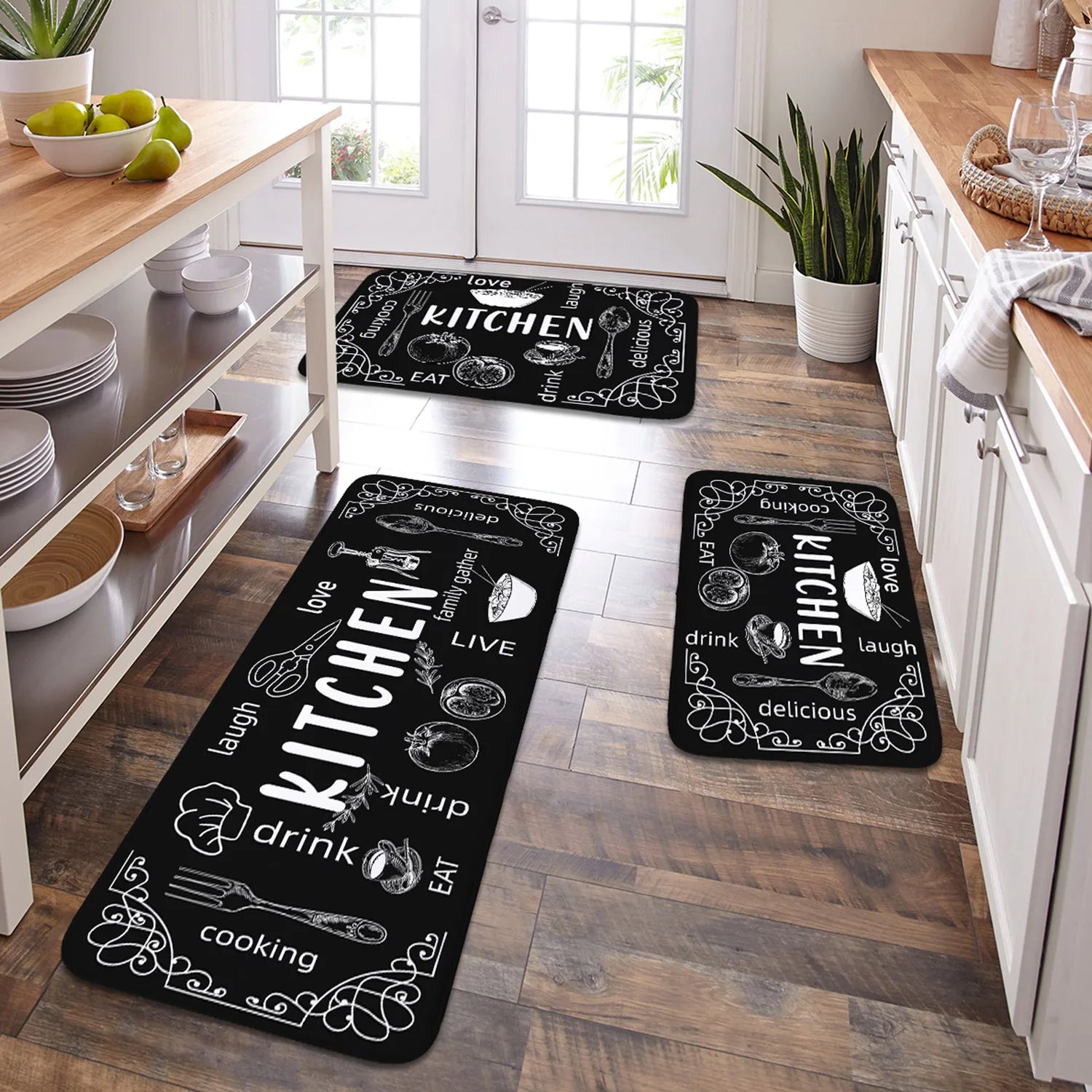 Black kitchen rugs with white text and graphics on a wooden floor.