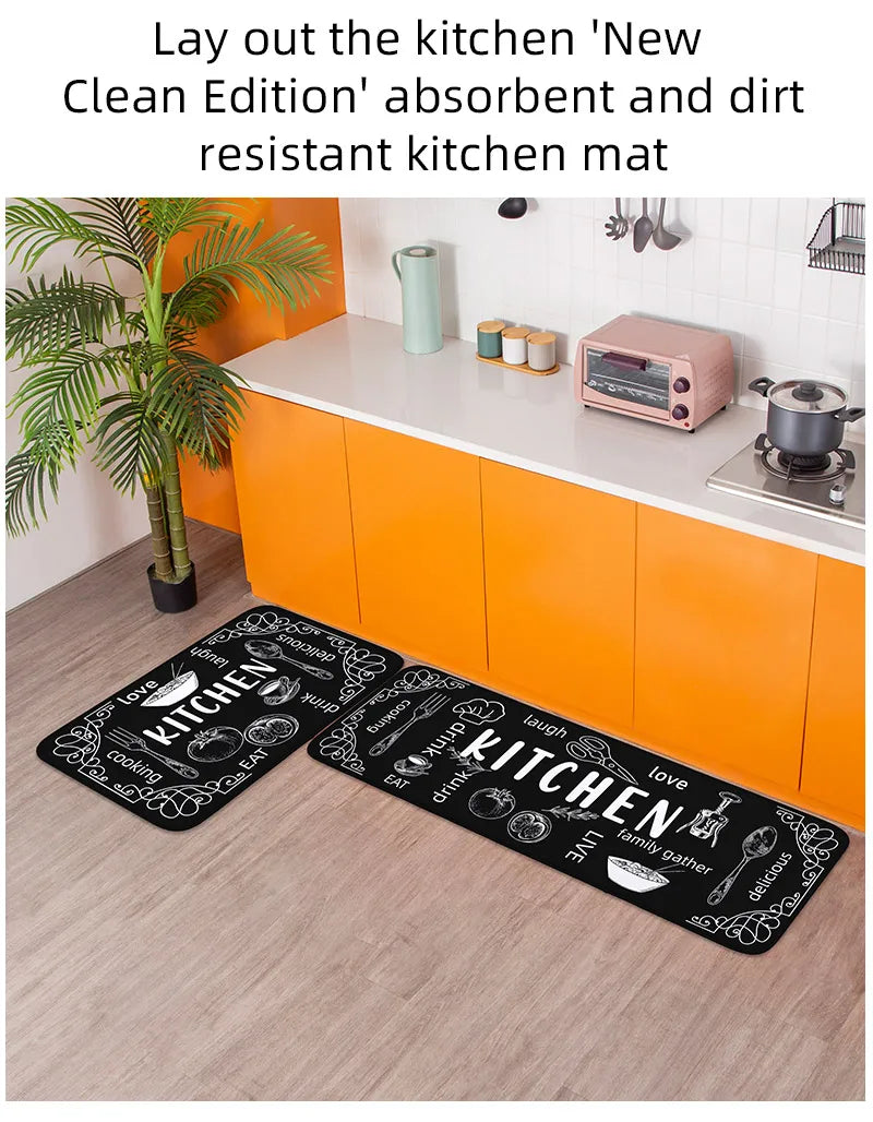 Black kitchen mat with white text on a wooden floor in a modern kitchen.