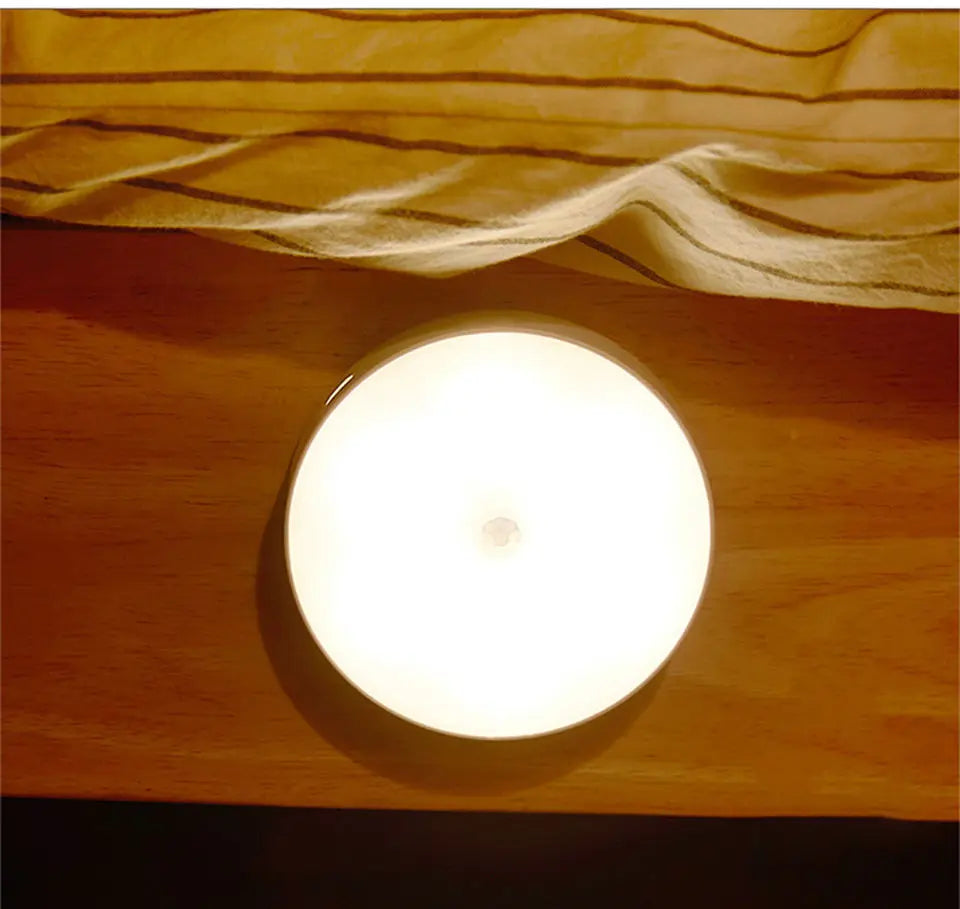 Round light fixture on a wooden surface with draped fabric above