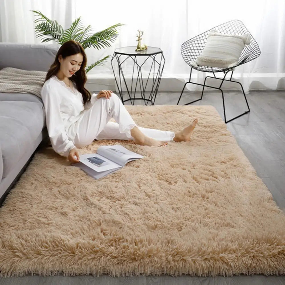 Woman reading a book on a fluffy beige rug in a modern living room.
