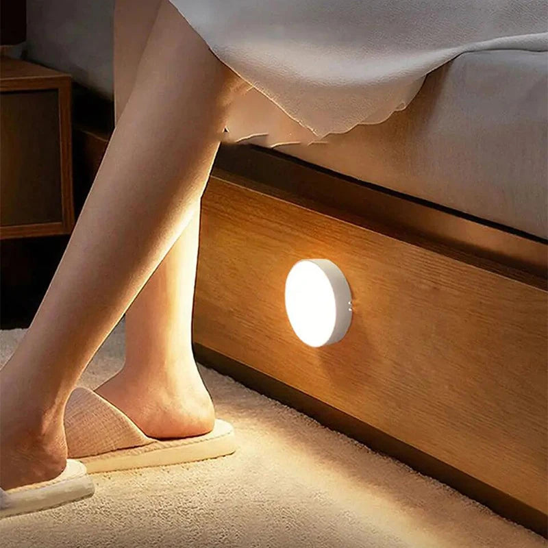 Person wearing slippers near a wooden nightstand with a night light on.