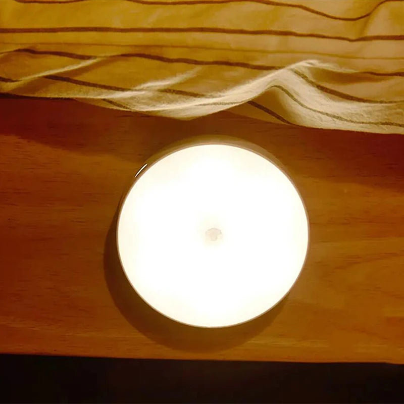 Round light bulb on a wooden surface with fabric draped above