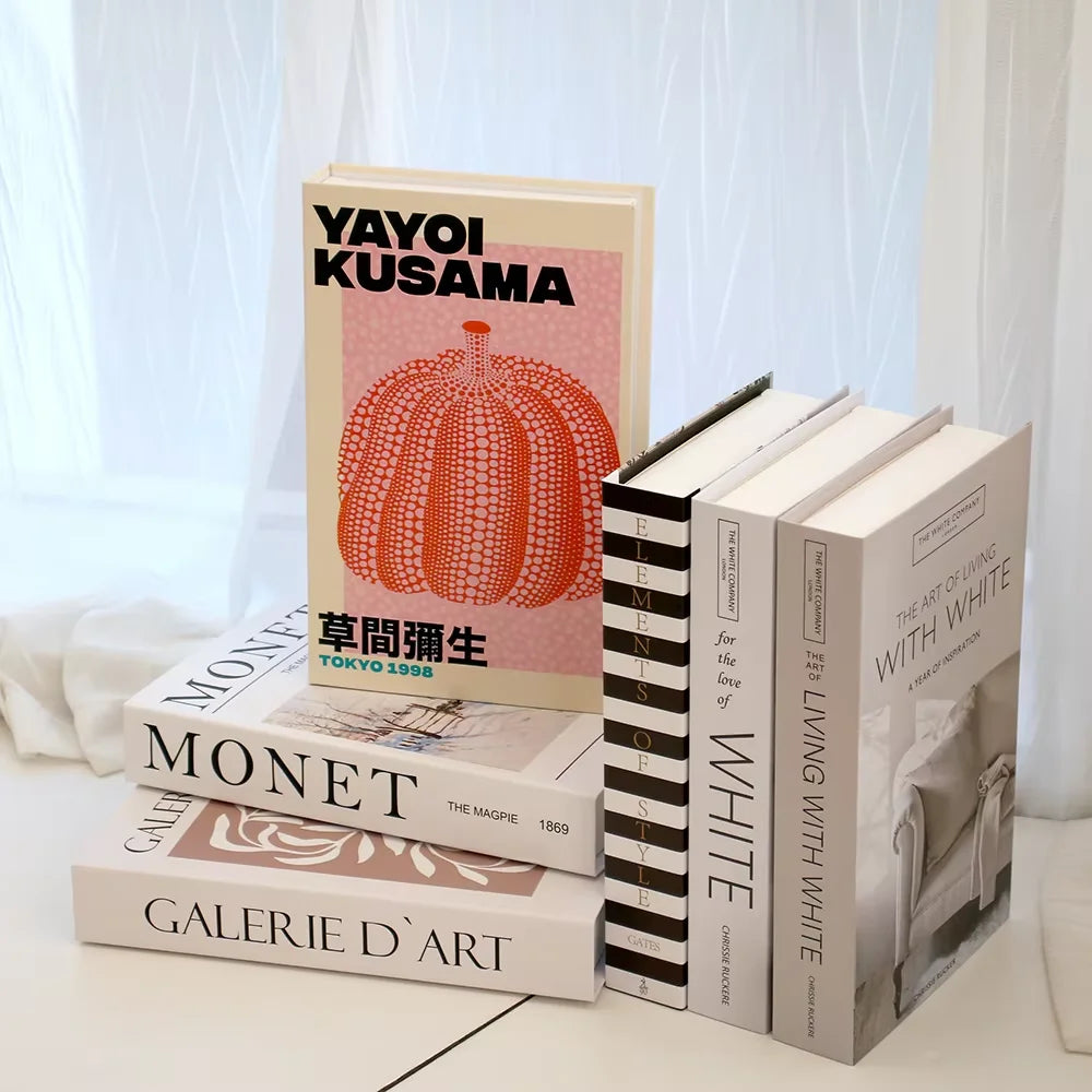Stack of books with visible titles and covers on a light surface.