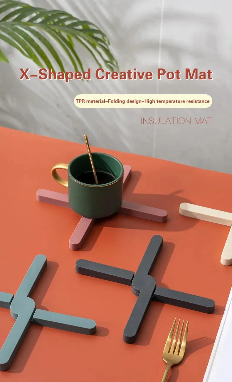 X-shaped creative pot mat with a green mug and gold fork on an orange surface.