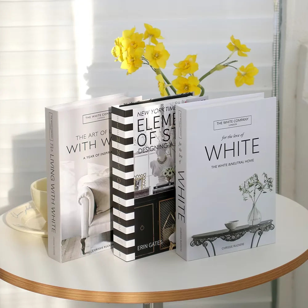 Three books on a table with yellow flowers in the background