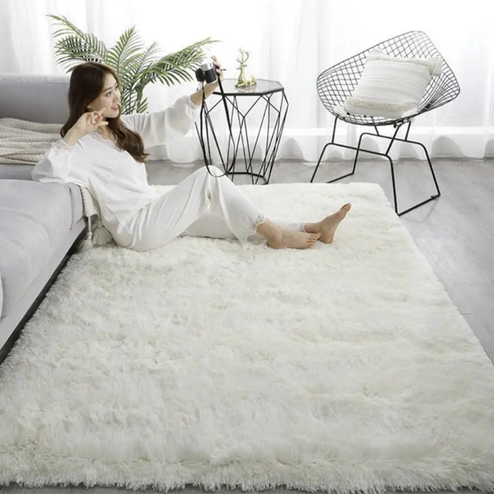 Woman taking a selfie on a fluffy white rug in a modern living room.