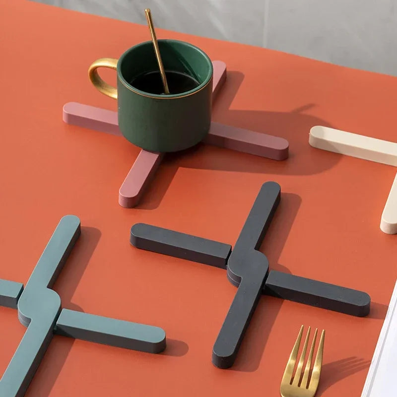 Green mug on a unique holder with geometric shapes on an orange surface