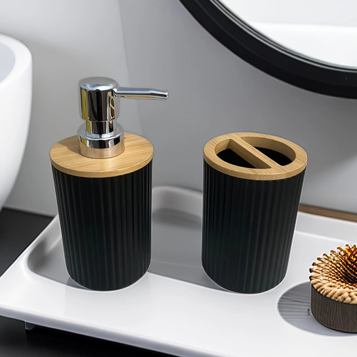 Bathroom set with black and wooden dispenser and toothbrush holder on a white tray.