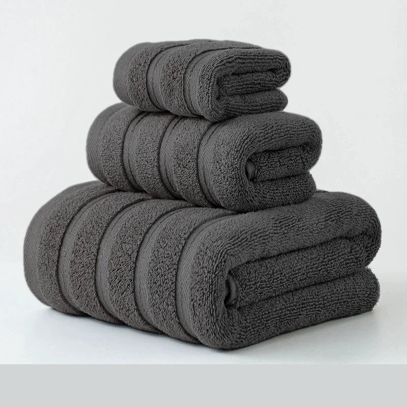 Stack of folded dark gray towels on a light gray background